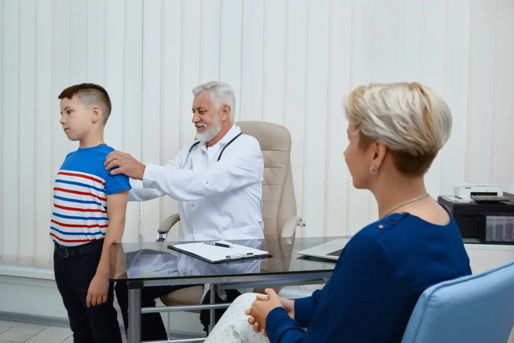 Clínica del Crecimiento | déficit hormonal de crecimiento,qué es déficit hormonal de crecimiento,síntomas de deficiencia de hormona de crecimiento,causas de la deficiencia de la hormona de crecimiento,tratamiento seguro hormona crecimiento Niño en consulta médica mostrando su curva de crecimiento — síntomas de deficiencia de hormona de crecimiento