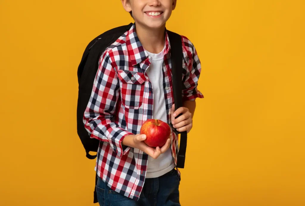 Niño con mochila y comida listo para el regreso a clases- clinica del crecimiento