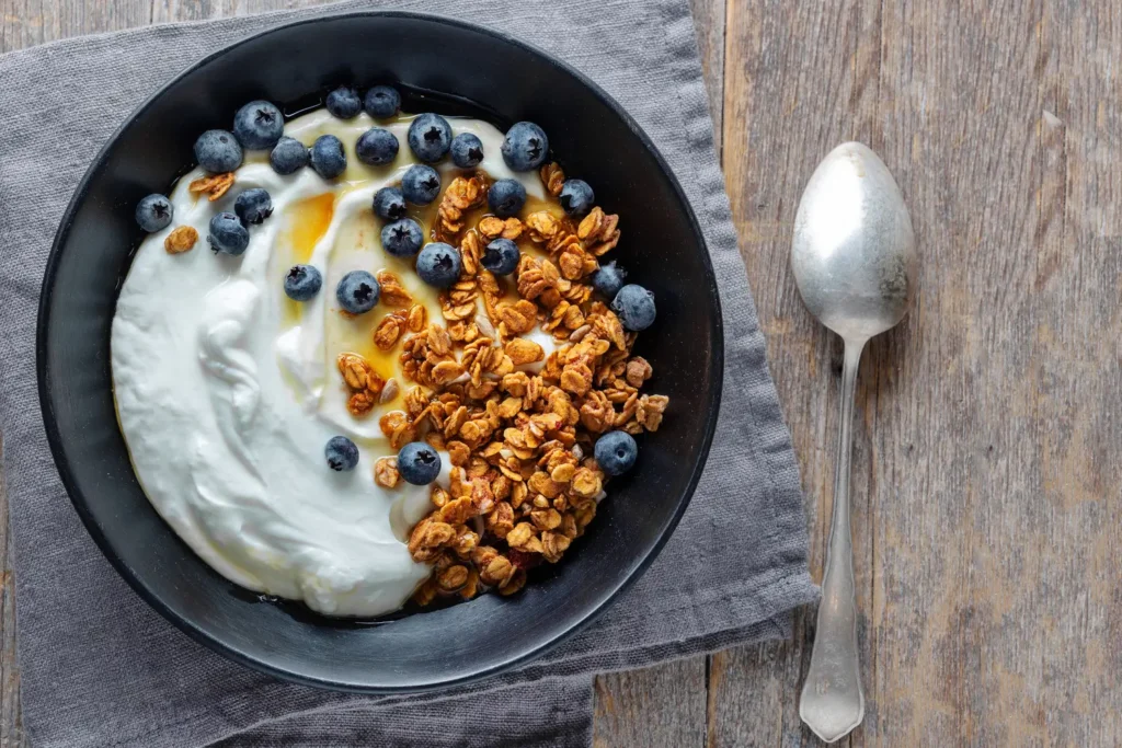 Desayuno con alimentos ricos en proteínas yogur griego con frutos secos