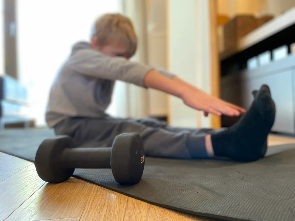Niño haciendo ejercicio al aire libre para fortalecer los huesos - clinica del crecimiento